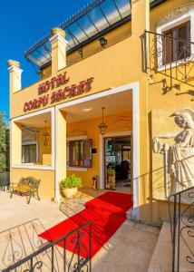 un bâtiment avec un tapis rouge devant lui dans l'établissement Corfu Secret Hotel, à Ýpsos