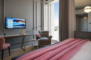 a living room with a couch and a television at Hotel Excelsior in Dubrovnik