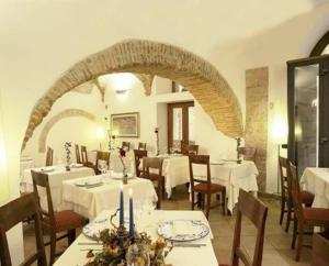 a restaurant with white tables and chairs and an archway at Hotel Italia in Foligno