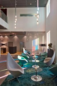 a lobby with chairs and tables on a rug at Trafo Hotel Baden in Baden