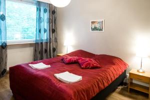 a bedroom with a red bed with two towels on it at Apartamentos Joensuu - Kauppakatu 9 in Joensuu