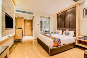 een hotelkamer met een groot bed en een televisie bij FabHotel Prime V Hazratganj in Lucknow