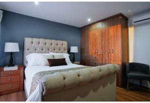 塞拉亞的住宿－Ventura Apartments，一间卧室配有一张大床和一个木制橱柜