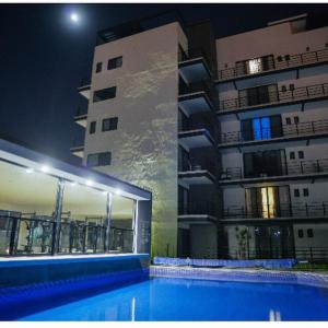 a swimming pool in front of a building at night at Ventura Apartments in Celaya