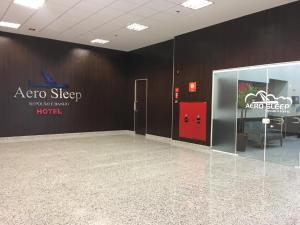 una habitación vacía con un cartel en la pared y una puerta en Hotel Aero Sleep Campinas en Campinas