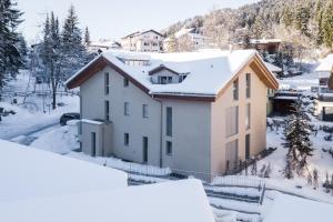 a house in the snow with snow covered trees at Casa Mutta in Laax