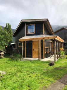a house with a large porch and a window at Cabanas Senderos Puyuhuapi in Puerto Puyuhuapi