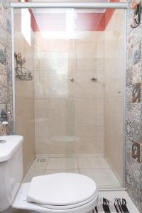une salle de bain avec douche et toilettes dans l'établissement Pousada Jardim da Nova Era, à Alto Paraíso de Goiás