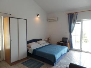 1 dormitorio con 1 cama y puerta corredera de cristal en Apartmani Vjera en Ribarica