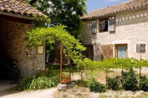 a garden in front of a stone house at La Vayssade - Grand Gîte de charme - 14 pers - Piscine & Jacuzzi in Lalbenque