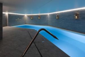 una piscina in una stanza con illuminazione blu di St-Alban Hotel & Spa a La Clusaz