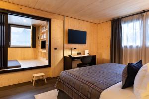 a bedroom with a bed and a desk and a window at St-Alban Hotel & Spa in La Clusaz +47 photos
