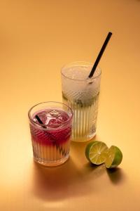 two glasses of liquid and a lime on a table at St-Alban Hotel & Spa in La Clusaz