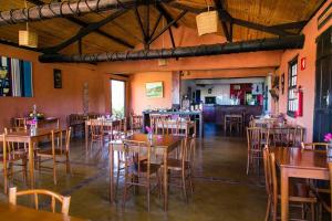 a restaurant with tables and chairs in a room at Pousada Buieié in Lavras Novas