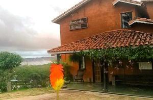 a building with a colorful bird statue in front of it at Pousada Buieié in Lavras Novas