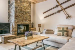 a living room with a couch and a fireplace at Val de Ruda Luxe 33 by FeelFree Rentals in Baqueira-Beret
