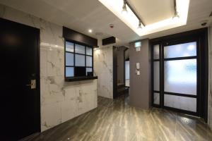 um corredor com paredes de mármore e uma porta de vidro em Top Motel Busan em Busan