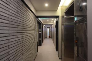un couloir d'un bâtiment avec un mur en briques dans l'établissement Top Motel Busan, à Busan