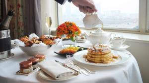 a table with a breakfast of pancakes and pastries at The Savoy in London