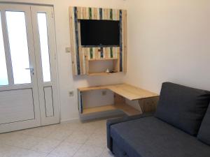 a living room with a tv and a table and a couch at Guest House Adriatica by Pinch in Pakoštane