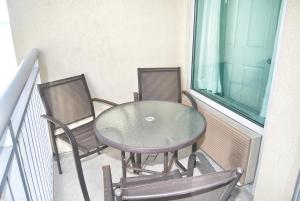 - Balcón con mesa de cristal y 2 sillas en Grand Atlantic Resort 601 Eff Condo en Myrtle Beach