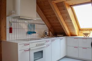 a kitchen with white cabinets and a window at Haus am Wasserfall in Mellau +25 photos