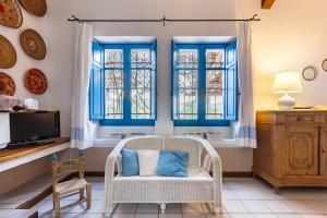 a living room with blue windows and a wicker chair at Casa Casciu La collina sul mare in Costa Rei