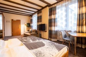 a bedroom with a bed and a desk and a chair at Hotel Ahrbella in Bad Neuenahr-Ahrweiler