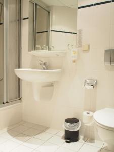 bagno bianco con lavandino e servizi igienici di Pension Ottendorf-Okrilla a Ottendorf-Okrilla