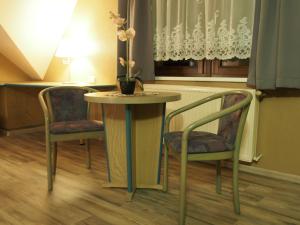 a table with two chairs and a table with flowers on it at Pension Ottendorf-Okrilla in Ottendorf-Okrilla