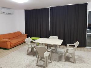a living room with a table and chairs and a couch at Apartments Alexandra in Pleven