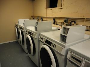 a row of white washing machines in a laundry room at Stratford Motel in Whitehorse