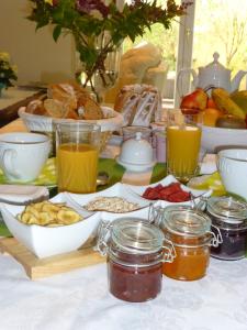 una mesa con comida para el desayuno y bebidas en ella en Chambres d'hôtes La ParentheZ', en Haguenau