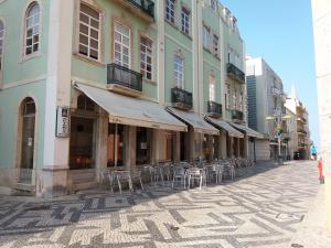 a street with tables and chairs in front of a building at Hotel Alianca in Figueira da Foz