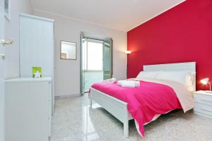 um quarto com uma parede vermelha e uma cama em A CASA DELL'ARTISTA em Roma