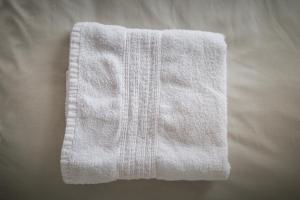 a white towel sitting on top of a bed at New In Newcastle in Newcastle +65 photos