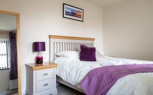 a bedroom with a bed with a purple blanket at New In Newcastle in Newcastle