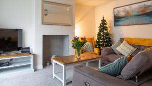 a living room with a couch and a christmas tree at New In Newcastle in Newcastle