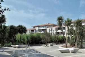 a building with palm trees in front of a courtyard at Luxury & Exclusive Resort in Saint-Tropez