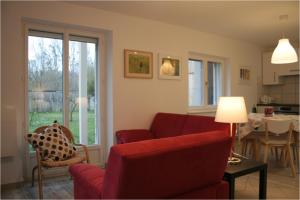 - un salon avec un canapé rouge et une table dans l'établissement Gîtes du Tilleul, à Niederbronn
