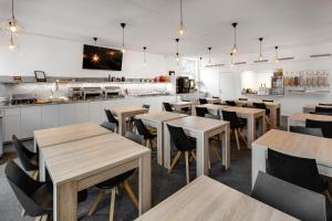 a restaurant with wooden tables and chairs and a counter at Almnäs Park Hotel in Södertälje