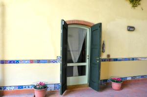 una porta sul lato di un edificio con due piante di Casa Petra a Vigasio