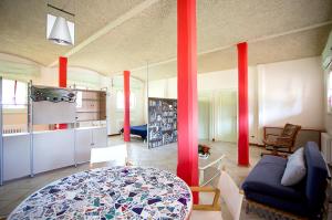 a living room with red columns and a blue couch at Casa Petra in Vigasio