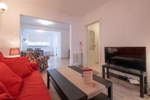 a living room with a red couch and a flat screen tv at LZ Spacious One Bedroom Apartment in Top Centre in Sofia