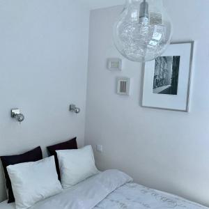 ワルシャワにあるAPARTELLO Modern Apartment - Wilanówのベッドルーム1室(ベッド1台、シャンデリア付)