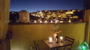 un tavolo con candele e una vista sulla città di notte di TrinaSicula Ragusa Ibla a Ragusa