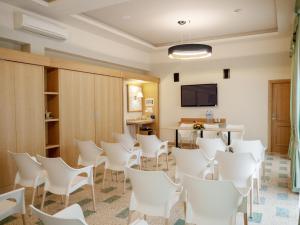 Pokój z białymi krzesłami, stołem i telewizorem w obiekcie Hotel Del Golfo w mieście Formia