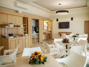 poczekalnia ze stołami i białymi krzesłami w obiekcie Hotel Del Golfo w mieście Formia