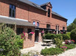 a brick building with a table in front of it at Gîtes de la maison du haras in Beuvron-en-Auge