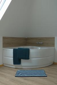 a bath tub in a bathroom with a blue towel at Heidebos in Het Laar